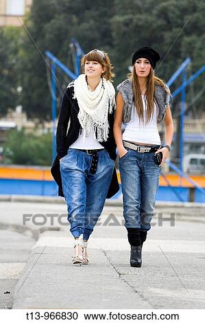 Two young women are walking towards camera View Large Photo Image Stock Image - Two young women are walking towards camera. Fotosearch
