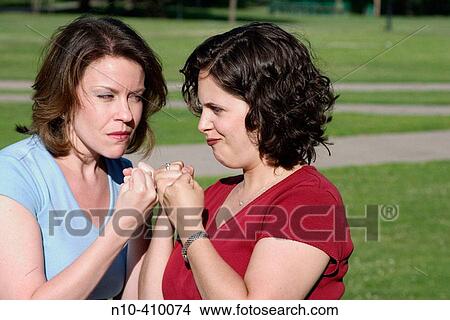 Two young women, at a park in Hartford, Connecticut, USA, pretending to be mad at each other. View Large Photo Image Picture - Two young women, at a park in Hartford, Connecticut, USA, pretending to be mad at each other.. Fotosearch