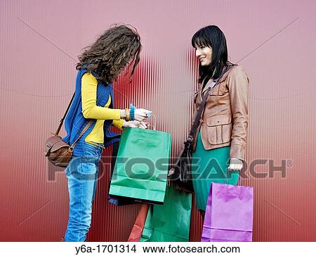 Two young women outdoors with shopping bags View Large Photo Image Picture - Two young women outdoors with shopping bags. Fotosearch