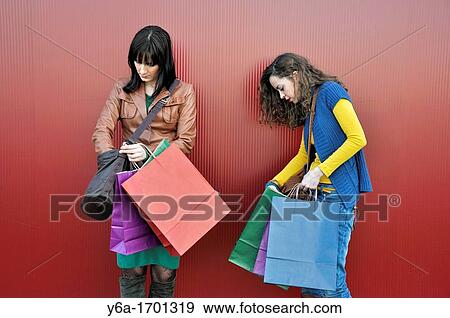 Stock Photo - Two young women outdoors with shopping bags. Fotosearch