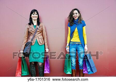 Two young women outdoors with shopping bags View Large Photo Image Stock Photograph - Two young women outdoors with shopping bags. Fotosearch