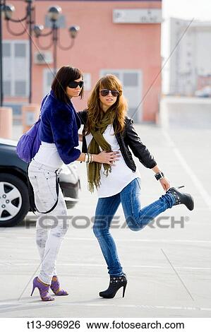 Stock Photograph - Two young women posing on the street. Fotosearch