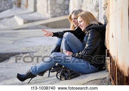 Two young women showing something in the distance View Large Photo Image Stock Image - Two young women showing something in the distance. Fotosearch