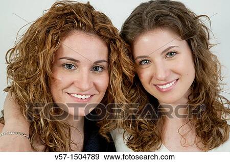 Two young women smiling and looking at the camera. Close view. View Large Photo Image Stock Photo - Two young women smiling and looking at the camera. Close view.. Fotosearch