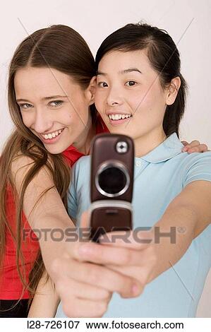two young women taking picture View Large Photo Image Stock Photo - two young women taking picture. Fotosearch
