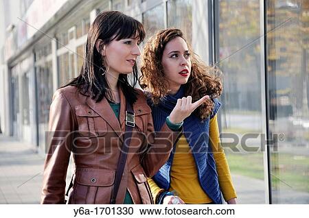 Stock Image - Two young women window shopping. Fotosearch