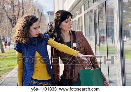 Two young women window shopping View Large Photo Image Stock Image - Two young women window shopping. Fotosearch