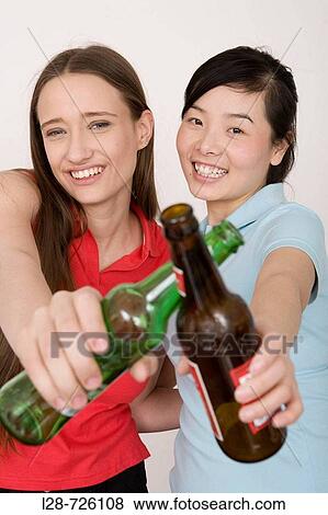 Two young women with alcoholic drinks, portrait View Large Photo Image Stock Photo - Two young women with alcoholic drinks, portrait. Fotosearch