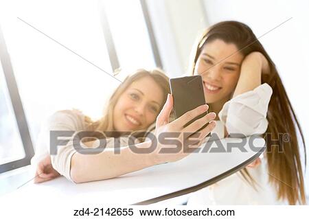 Two young women with smartphones View Large Photo Image Stock Photography - Two young women with smartphones. Fotosearch