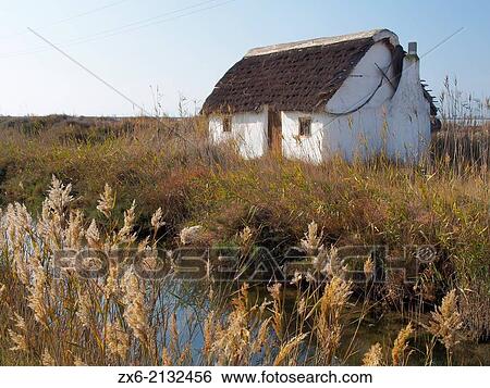 Typical adobe hut at La Tancada Lagoon. Ebro River Delta Natural Park, Tarragona province, Catalonia, Spain. View Large Photo Image Stock Photograph - Typical adobe hut at La Tancada Lagoon. Ebro River Delta Natural Park, Tarragona province, Catalonia, Spain.. Fotosearch