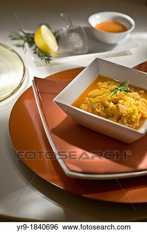Stock Photograph - Typical Spanish rice recipe,? arroz caldoso? (broth-like rice) with squids and seafood. Fotosearch
