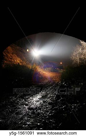 Stock Image - tyre tracks in mud under bridge at night. Fotosearch
