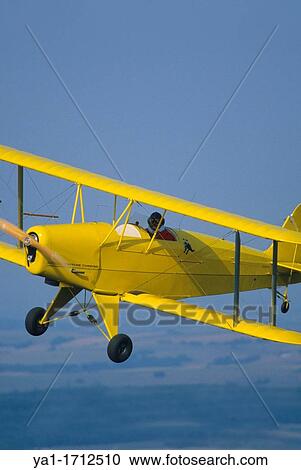 Stock Image - Ultra light biplane Kiebitz flying over France. Fotosearch