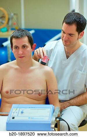Stock Image - Ultrasound to treat trapezius muscle contractures Physiotherapy medical center, Donostia, San Sebastian, Gipuzkoa, Basque Country, Spain. Fotosearch