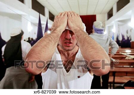 Stock Photo - Un penitente se prepara para salir en la Semana Santa de Granada, Espaa., A penitent is preparing to leave at Easter in Granada, Spain.. Fotosearch