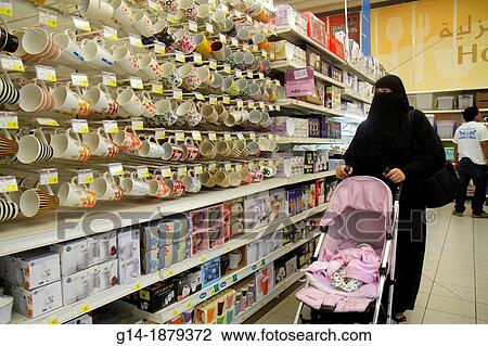 Stock Image - United Arab Emirates, U A E, UAE, Middle East, Dubai, Al Souqe Al Kabeer, Carrefour Hyper Market, shopping, department, store, for sale, packaging, English, Arabic, language, Middle Eastern, woman, thawb, hijab, burqa, stroller, baby, mugs, cups,. Fotosearch