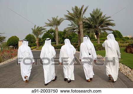 Stock Image - United Arab Emirates (UAE), Abu Dhabi, Sir Bani Yas island, five bearded men in white kandoura dishdash. Fotosearch