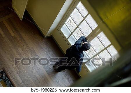 Unrecognizable man talking on phone looking through a window View Large Photo Image Stock Photography - Unrecognizable man talking on phone looking through a window. Fotosearch