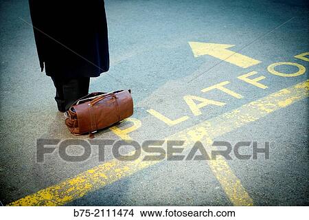 Unrecognizable man with a suitcase on the floor, waiting on the platform at the York train station. Yorkshire, England, UK, Europe. View Large Photo Image Picture - Unrecognizable man with a suitcase on the floor, waiting on the platform at the York train station. Yorkshire, England, UK, Europe.. Fotosearch