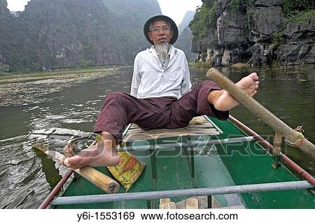 Stock Photo - Unusual foot rowing Tam Coc area of Ngo Dong River near Ninh Binh north Vietnam. Fotosearch