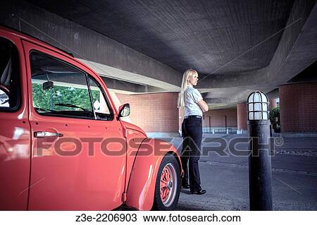 Stock Image - urban portrait of a young woman with a classic car.. Fotosearch