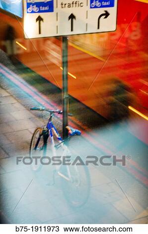 Stock Image - Urban traffic and street bike parked on a road sign in Victoria Station, London, England, UK. Fotosearch