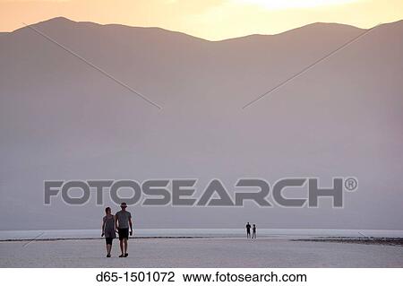 Stock Image - USA, California, Death Valley National Park, Badwater, elevation 282 feet below sea level, lowest point in the Western Hemisphere, sunset view with visitors, NR. Fotosearch