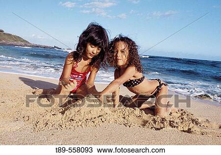 Stock Image - USA, Hawaii, Girls playing on the Beach. Fotosearch