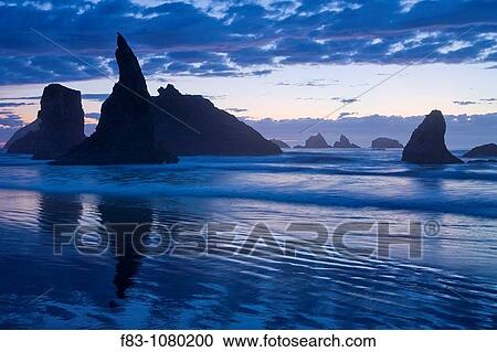 Stock Image - USA, Oregon, Coos County, Bandon State Park, sea stacks, surf, and beach at sunset, September. Fotosearch
