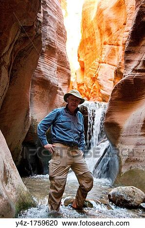 Stock Image - USA Utah, hike up the slot canyon known as Kanarra Creek, near Zion National Park, showing the red iron oxide rocks and the water stream erosion creating magnificent scenery MR. Fotosearch
