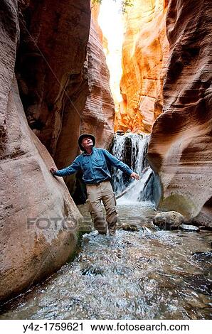 Stock Image - USA Utah, hike up the slot canyon known as Kanarra Creek, near Zion National Park, showing the red iron oxide rocks and the water stream erosion creating magnificent scenery MR. Fotosearch