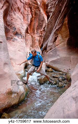 USA Utah, hike up the slot canyon known as Kanarra Creek, near Zion National Park, showing the red iron oxide rocks and the water stream erosion creating magnificent scenery MR View Large Photo Image Stock Photo - USA Utah, hike up the slot canyon known as Kanarra Creek, near Zion National Park, showing the red iron oxide rocks and the water stream erosion creating magnificent scenery MR. Fotosearch