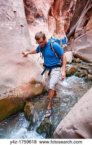 USA Utah, hike up the slot canyon known as Kanarra Creek, near Zion National Park, showing the red iron oxide rocks and the water stream erosion creating magnificent scenery MR View Large Photo Image Stock Photo - USA Utah, hike up the slot canyon known as Kanarra Creek, near Zion National Park, showing the red iron oxide rocks and the water stream erosion creating magnificent scenery MR. Fotosearch