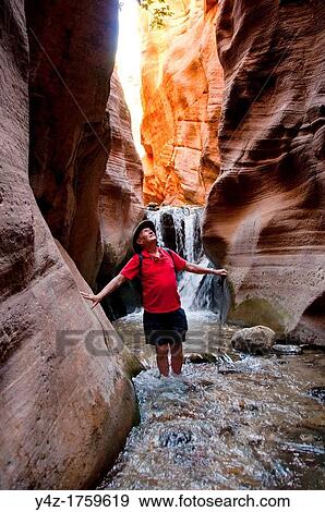 Stock Photo - USA Utah, hike up the slot canyon known as Kanarra Creek, near Zion National Park, showing the red iron oxide rocks and the water stream erosion creating magnificent scenery MR. Fotosearch