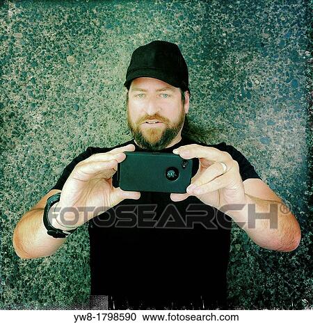 Stock Image - Using a smart phone to take a picture. Fotosearch