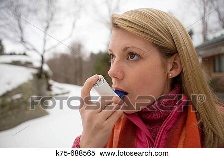 Stock Photography - Using bronchial inhaler outdoors. Fotosearch