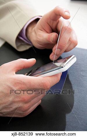 Stock Photo - Using cell phone, touchscreen. Fotosearch
