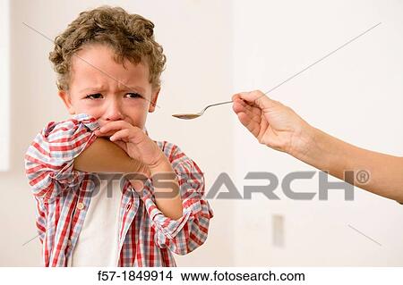 Uunhappy four year old being given medicine View Large Photo Image Picture - Uunhappy four year old being given medicine. Fotosearch