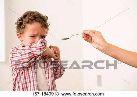 Uunhappy four year old being given medicine View Large Photo Image Stock Photo - Uunhappy four year old being given medicine. Fotosearch
