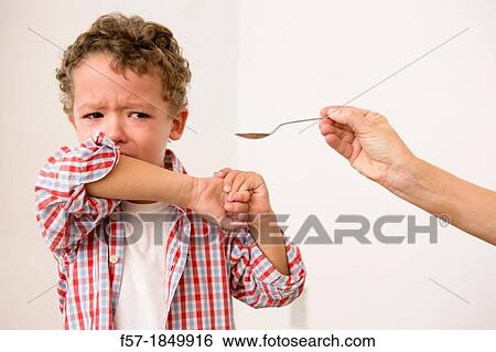 Uunhappy four year old being given medicine View Large Photo Image Stock Photograph - Uunhappy four year old being given medicine. Fotosearch