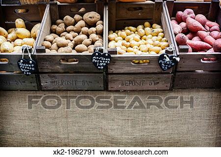 Stock Image - Variety of potatoes in different wooden boxes, Borough Market, London, UK. Fotosearch