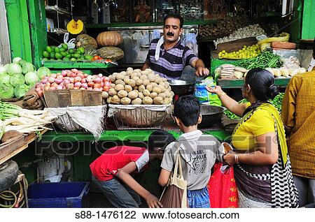 Stock Image - Vegetable shop at the market, New Delhi, India. Fotosearch