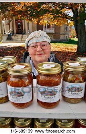 Vendor of home made preserves, pickles and relishes sells her product directly to the public from farmstand View Large Photo Image Stock Photo - Vendor of home made preserves, pickles and relishes sells her product directly to the public from farmstand. Fotosearch