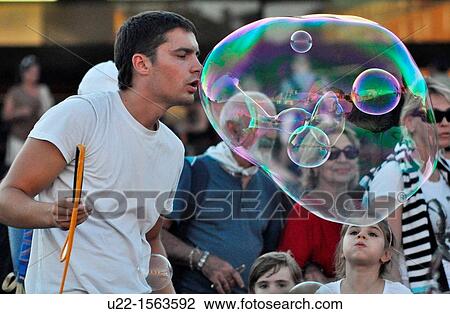 Venezia (Italy): a young man making a huge soap bubble by the train station View Large Photo Image Stock Image - Venezia (Italy): a young man making a huge soap bubble by the train station. Fotosearch
