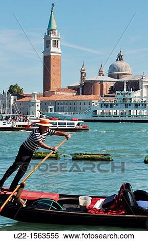Venezia (Italy): gondoliere at work along Canale di San Marco; the Isola di San Giorgio Maggiore on the background View Large Photo Image Stock Photography - Venezia (Italy): gondoliere at work along Canale di San Marco; the Isola di San Giorgio Maggiore on the background. Fotosearch