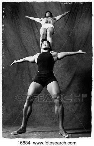 Vertical, black and white studio portrait of bodybuilding woman balancing man on top of her shoulders View Large Photo Image Picture - Vertical, black and white studio portrait of bodybuilding woman balancing man on top of her shoulders. Fotosearch