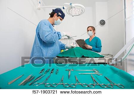 Stock Image - Veterinarians operating on a dog in their surgery. Fotosearch
