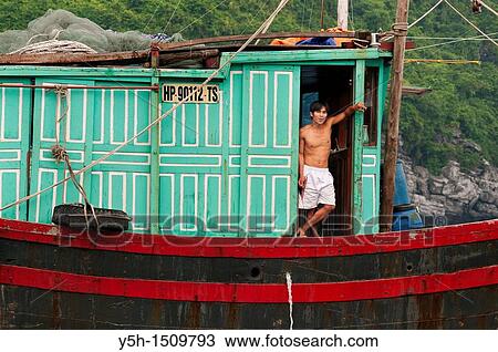 Stock Image - Vietnam Cat Ba Bay Man on his boat. Fotosearch
