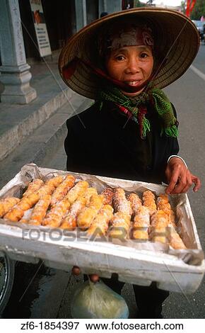 Vietnam Hanoi city center woman straw hat selling bread View Large Photo Image Stock Photo - Vietnam Hanoi city center woman straw hat selling bread. Fotosearch