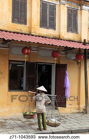 Stock Image - Vietnam, Hoi An, street scene, woman with baskets,. Fotosearch
